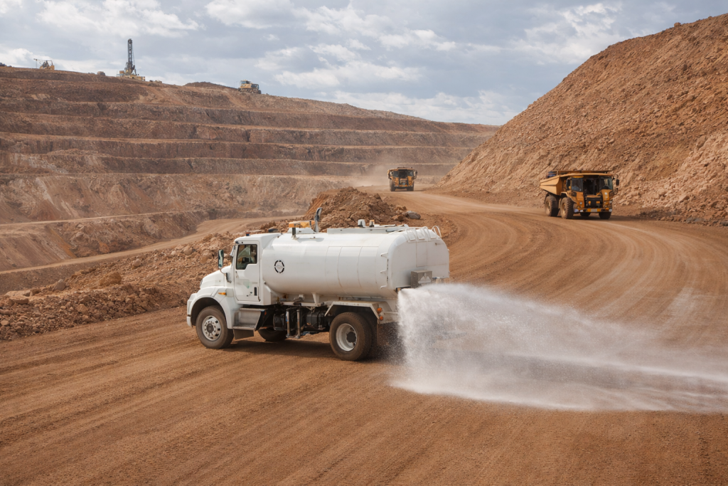 water truck spraying a road with chemical surfactant.