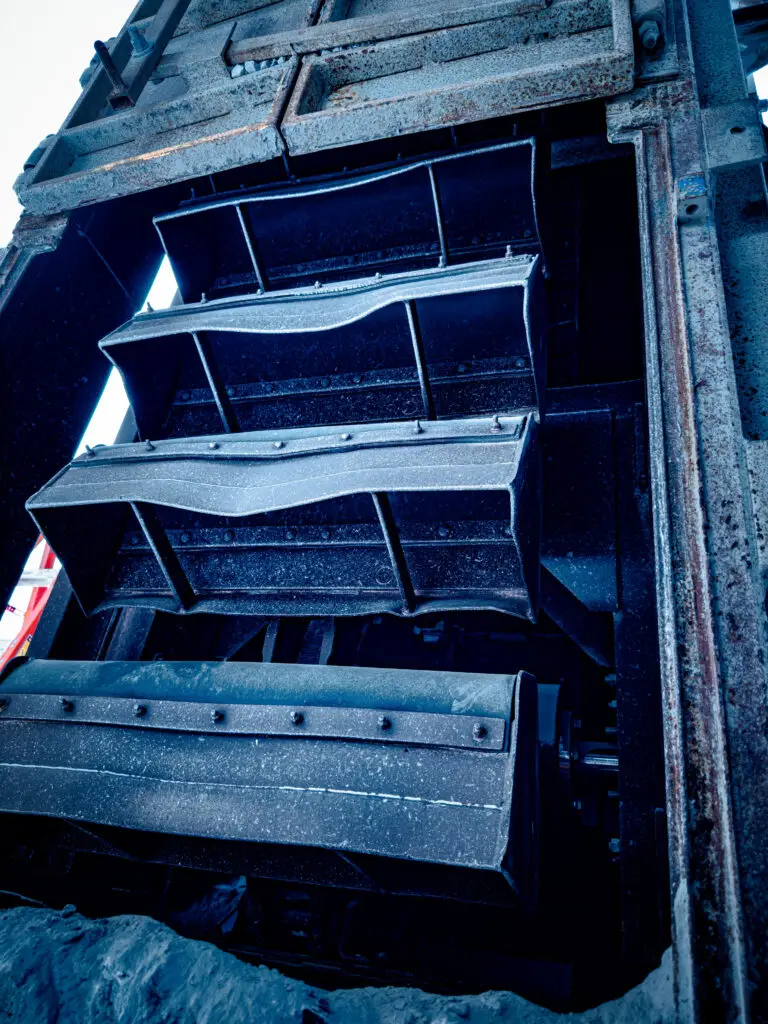 Close-up of buckets on a bucket elevator transporting materials.