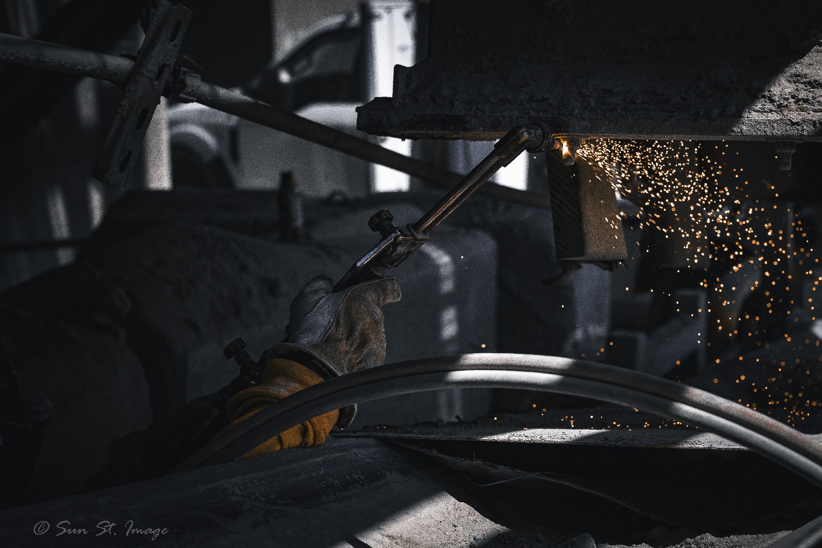Worker using an oxy-acetylene torch for cutting or welding metal.