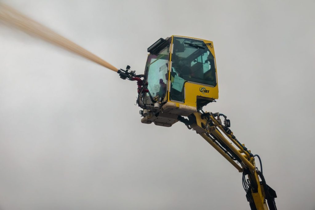 Aerial view of industrial machinery spraying water for dust suppression