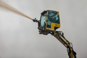 Aerial view of industrial machinery spraying water for dust suppression