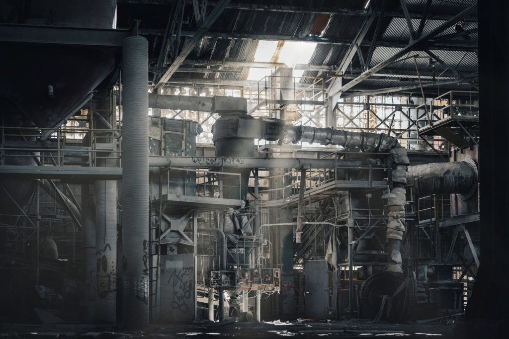 Dust-covered equipment and structural steel inside an industrial building
