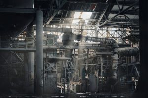 Dust-covered equipment and structural steel inside an industrial building