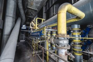 Close-up of yellow industrial piping and valves at a processing plant