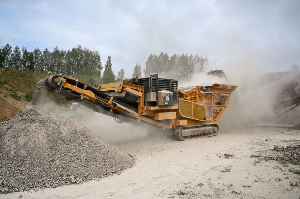 Crusher machine processing rock in a dusty quarry