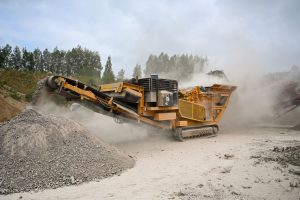 Crusher machine processing rock in a dusty quarry