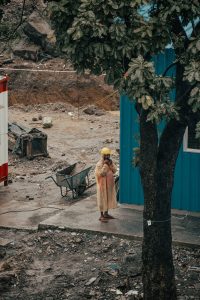 Worker in rain gear standing on a muddy industrial worksite